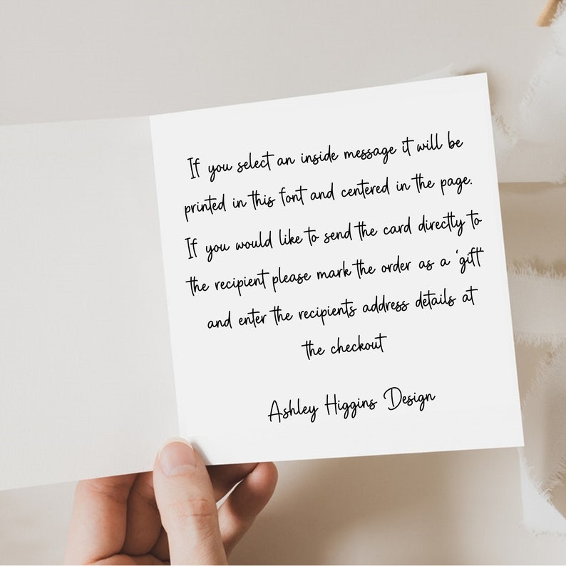 May include: A white greeting card with black handwritten text. The text provides instructions for sending a card directly to a recipient and selecting an inside message. The card is held by a hand.