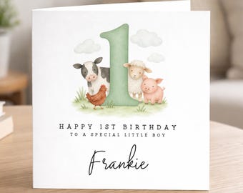 May include: A square white greeting card featuring a large sage green number one, a watercolor illustration of a cow, sheep, pig, and chicken on grass with clouds, and the text HAPPY 1ST BIRTHDAY TO A SPECIAL LITTLE BOY and the name Frankie.