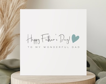 May include: A white card with the text "Happy Father's Day!" in black script font. Below the text is "To my wonderful Dad" in a smaller font. A light blue heart is to the right of the text.