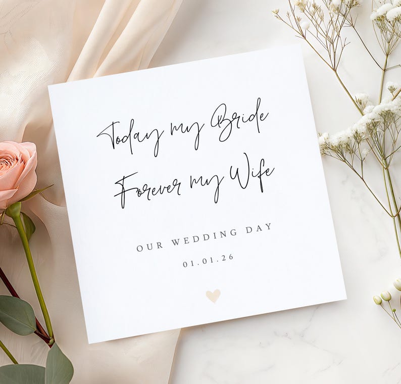 May include: A white square wedding card with black script that reads "Today my Bride, Forever my Wife." The card also includes "Our Wedding Day" and a date. A small peach heart is at the bottom. The card is surrounded by flowers.