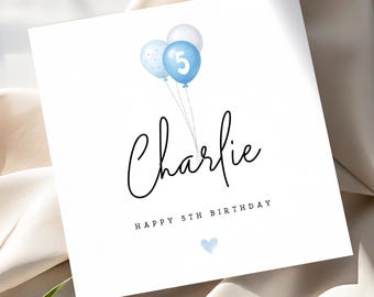May include: A white birthday card with the name "Charlie" in black script. Three blue balloons with the number 5 are at the top. The text "HAPPY 5TH BIRTHDAY" is below the name, with a small blue heart at the bottom.