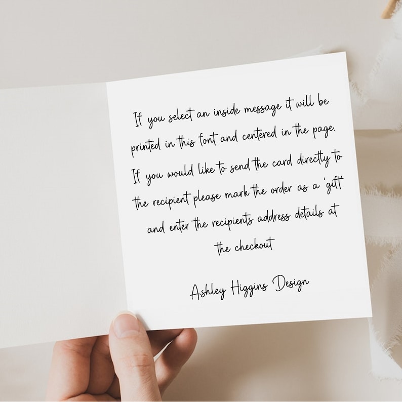 K&ouml;nnte beinhalten: Eine wei&szlig;e Gru&szlig;karte mit handschriftlichem schwarzem Text. Der Text enth&auml;lt Anweisungen zum direkten Versenden einer Karte an einen Empf&auml;nger und enth&auml;lt den Namen des Designers, "Ashley Higgins Design."