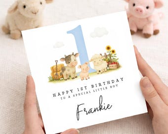 May include: A square birthday card featuring a large light blue number one, watercolor illustrations of a cow, pig, and sheep, and a crate of sunflowers. The text reads: Happy 1st Birthday to a special little boy, with the name Frankie below.