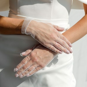May include: A pair of white sheer gloves