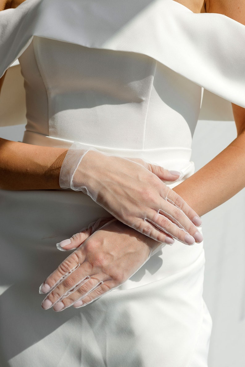 May include: A pair of white sheer gloves