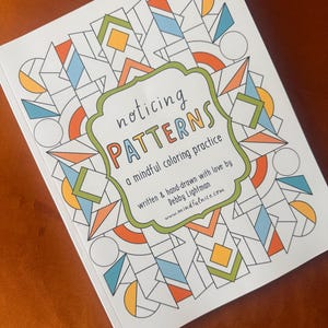 May include: A white coloring book titled Noticing Patterns: a mindful coloring practice, written & hand-drawn with love by Debby Lightman, featuring a geometric pattern of black lines filled with orange, blue, and yellow shapes on the cover.