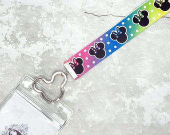 May include: A rainbow lanyard with white polka dots and black Minnie Mouse silhouettes. The lanyard has a clear plastic badge holder with the text "cheeky monkey supply company cheekymonkey.supply.com".