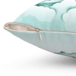 May include: A light blue throw pillow with a zipper closure. The pillow has a subtle cloud pattern.
