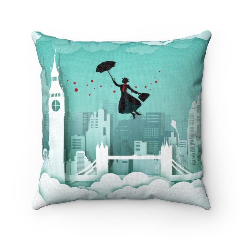 May include: A decorative throw pillow with a turquoise background featuring a silhouette of a woman flying with an umbrella over a cityscape of London. The cityscape includes Big Ben and the Tower Bridge.