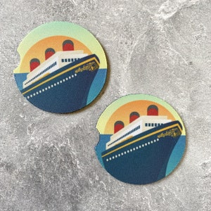 May include: Two round, colorful coasters featuring a vintage ocean liner with a yellow, blue, and white color scheme. The coasters are made of a cork-like material and are perfect for protecting surfaces from condensation.