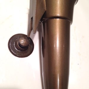 May include: A brown metal vase with a shiny finish. The vase has a wide opening at the top and a narrow base.