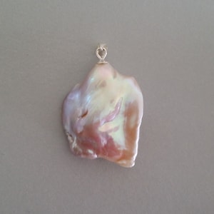 May include: A large, iridescent, pink and white baroque pearl pendant with a silver bail.