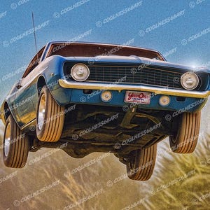 May include: A vintage blue classic car is captured mid-air, showcasing its front end with headlights and a license plate that reads "Year One." The car's tires are off the ground, with a blue sky background.