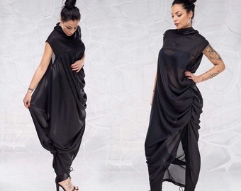 May include: A black, draped, sleeveless dress with a high neckline. The dress is made of a sheer fabric and has a flowing, asymmetrical design.