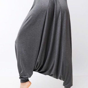 May include: Gray, loose-fitting pants with a wide, flowing leg. The pants have a gathered waist and a relaxed fit.