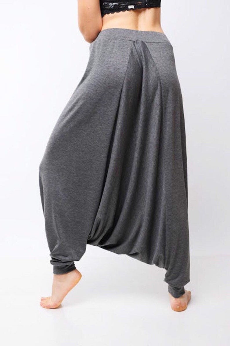 May include: Gray, loose-fitting pants with a wide, flowing leg. The pants have a gathered waist and a relaxed fit.