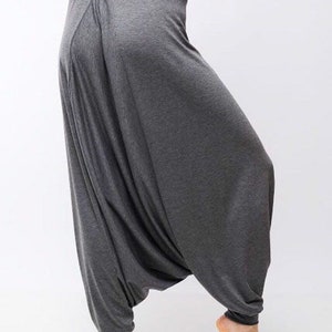 May include: Gray harem pants with a loose, flowing fit. The pants are made of a soft, comfortable fabric and have a wide, elastic waistband.