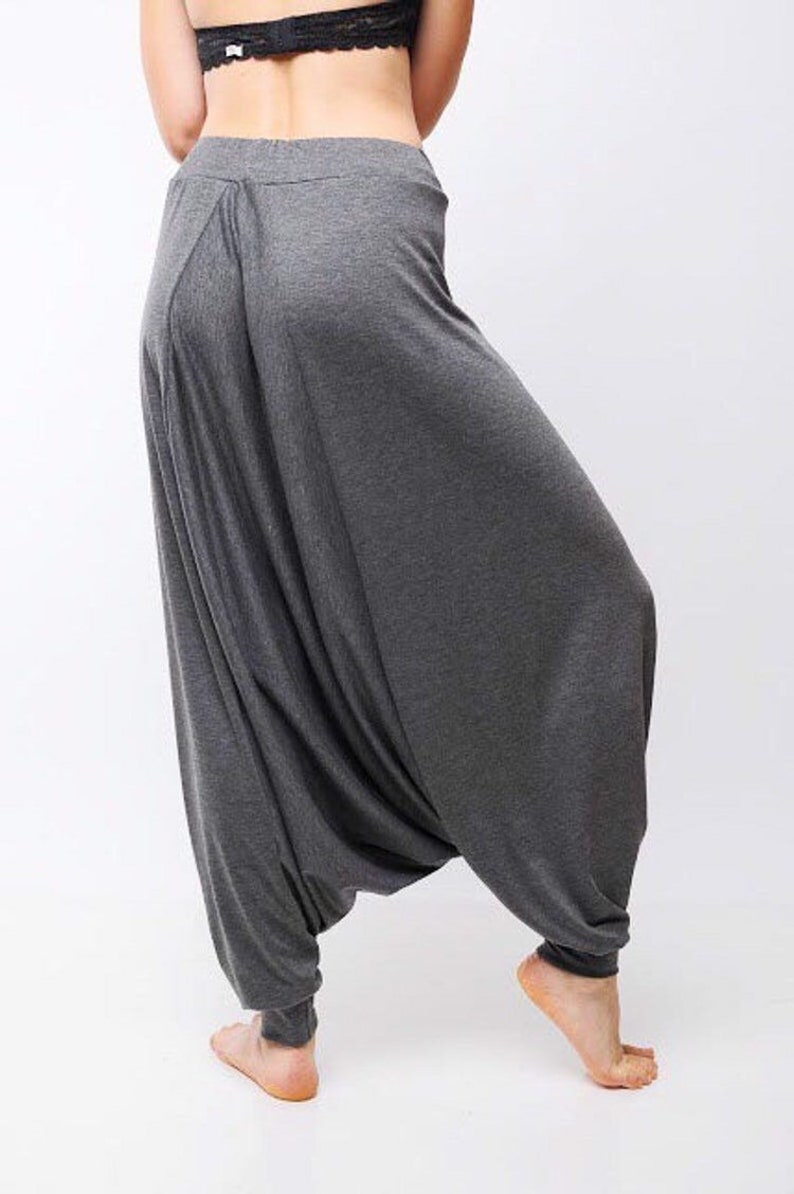 May include: Gray harem pants with a loose, flowing fit. The pants are made of a soft, comfortable fabric and have a wide, elastic waistband.