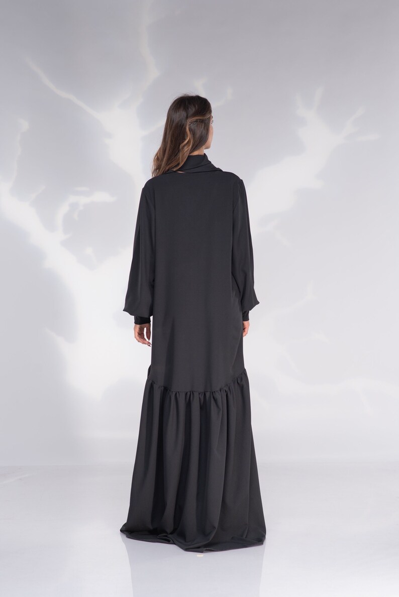 May include: A black long-sleeved dress with a high neck and a ruffled hem.