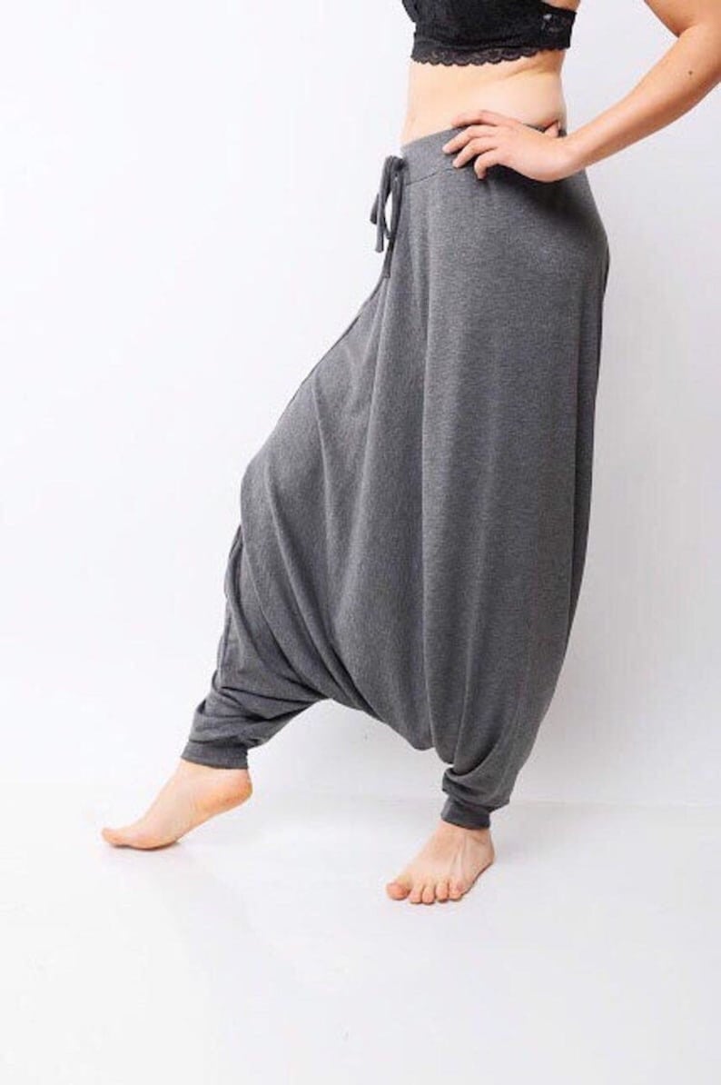 May include: Gray, loose-fitting pants with a drawstring waist. The pants are made of a soft, comfortable fabric and have a relaxed fit.
