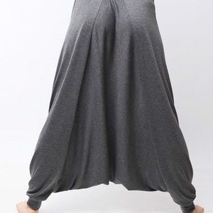 May include: Gray, loose-fitting pants with a wide leg and a gathered waist.