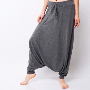 May include: Gray, loose-fitting pants with a drawstring waist. The pants are made of a soft, comfortable fabric and have a relaxed fit.