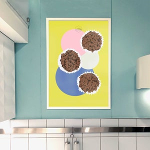 May include: A framed print with a yellow background and three brown chocolate truffles on a white background. The truffles are surrounded by pink, white, and blue circles.