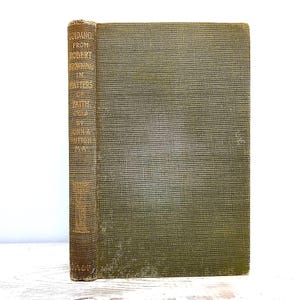 Puede incluir: Una taza de cerámica blanca con un asa negra y el texto "But First, Coffee" en negro, con una fuente de estilo manuscrito. La taza está sobre una superficie blanca.