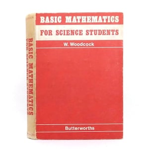 Puede incluir: Un libro antiguo titulado "Basic Mathematics for Science Students" de W. Woodcock. El libro tiene una cubierta roja con texto blanco y un lomo beige. El nombre del editor, Butterworths, está en la parte inferior.