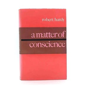 May include: A hardcover book titled "a matter of conscience" by Robert Hardy. The book has a red cover with a brown band across the middle. The title is in pink lettering.