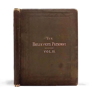 May include: A vintage, dark brown book titled "The Believer's Pathway, Vol. II." The book has a worn, textured cover with embossed gold lettering. The spine is visible, showing signs of age and wear.