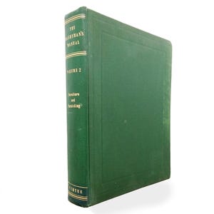 May include: A vintage green hardcover book titled "The Handyman's Manual, Volume 2: Furniture and Furnishing." The spine has gold lettering and a decorative border. The book is set against a white background.