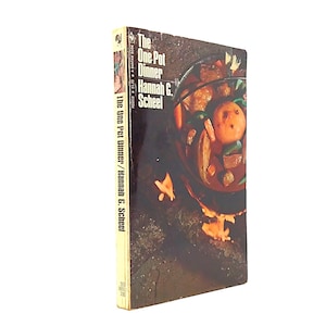 May include: A vintage paperback cookbook titled "The One Pot Dinner" by Hannah G. Scheel. The cover features a close-up image of a pot of stew with vegetables. The spine displays the title and author's name.