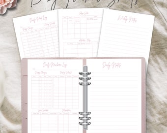 May include: A pink and white baby tracker binder with pages for daily and weekly notes, feeding schedules, nappy changes, and sleep schedules. The text "Baby Tracker Sheets" is at the top of the image. The text "PINK & BLUE PAGES INCLUDED WITH PURCHASE" is at the bottom of the image.