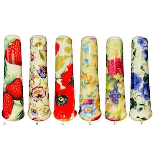 Puede incluir: Seis tiradores de cajón de cerámica con diferentes patrones florales. Los tiradores son blancos con diseños florales rojos, azules, amarillos y verdes. Los tiradores están etiquetados de la A a la F.