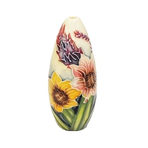 May include: An egg-shaped vase in cream, decorated with sunflowers and other flowers. The vase has yellow sunflowers, pink flowers, and green leaves. The top of the vase has a design of red and purple leaves.
