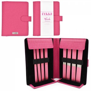 Puede incluir: Un estuche de cuero rosa con un juego de agujas de tejer de doble punta. El estuche tiene una etiqueta que dice "LYKKE" y "Blush Double-Pointed Birchwood Knitting Needle Set".