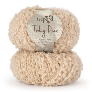 May include: A white ceramic mug with a black handle and the text "But First, Coffee" in a bold, black font. The mug is set against a blurred background, suggesting a cozy setting.