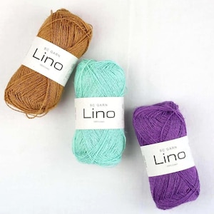 Peut inclure: Trois écheveaux de fil BC Garn Lino en marron, vert menthe et violet. Chaque écheveau porte une étiquette en papier blanc avec le texte BC Garn Lino 100% Linen imprimé en noir. Le fil présente un aspect texturé et fibreux.