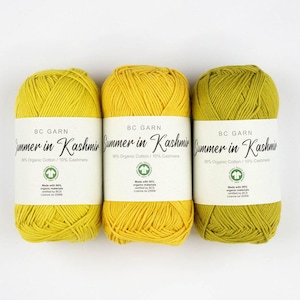 May include: Three skeins of yarn, one yellow, one yellow, and one green. The yarn is labeled 'BC Garn Summer in Kashmir 90% Organic Cotton/10% Cashmere' and 'Made with 90% organic materials certified by BCS Licence no 25056'.