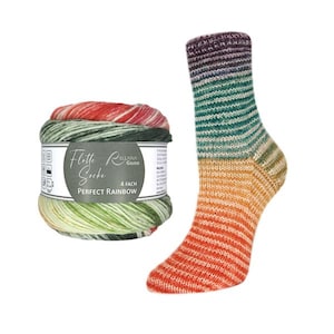 Puede incluir: Un calcetín a rayas multicolor y una madeja de lana a juego. El calcetín y la madeja presentan un degradado de colores arcoíris, con rojo, naranja, amarillo, verde y morado. La etiqueta de la lana dice "Flotte Socke PERFECT RAINBOW".