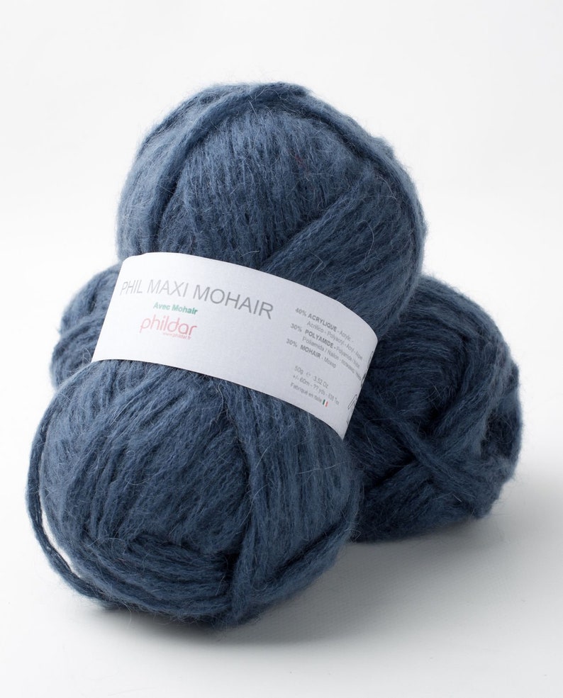 May include: Two balls of navy blue yarn with a white label wrapped around one. The label reads "PHIL MAXI MOHAIR" and lists the fiber content. The yarn is a soft, fluffy texture, perfect for knitting or crocheting projects.