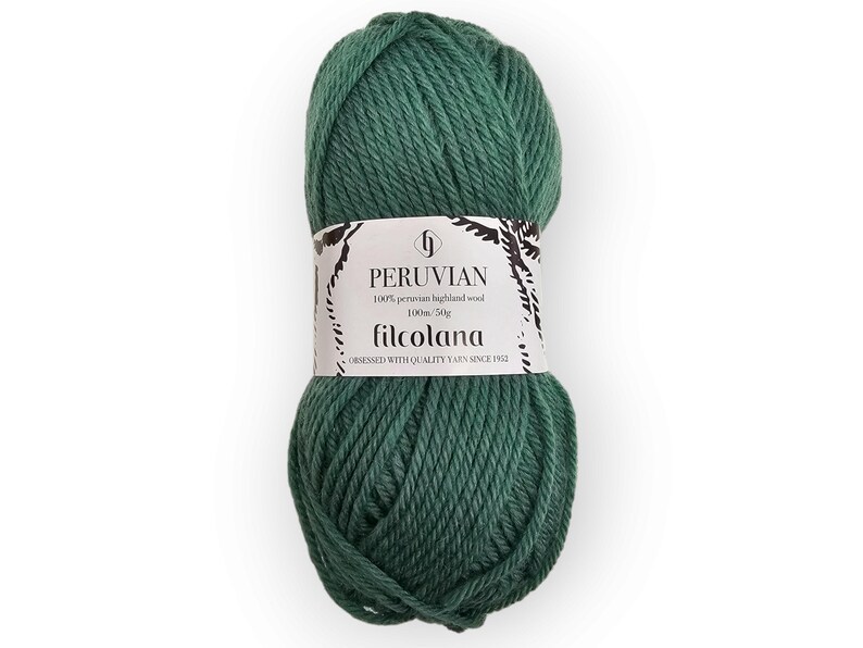 Op de afbeelding: Een bol donkergroen garen met een wit papieren label. Het label bevat de tekst PERUVIAN, 100% peruvian highland wool, 100m/50g en filcolana, samen met de zin OBSESSED WITH QUALITY YARN SINCE 1952 in zwarte letters.