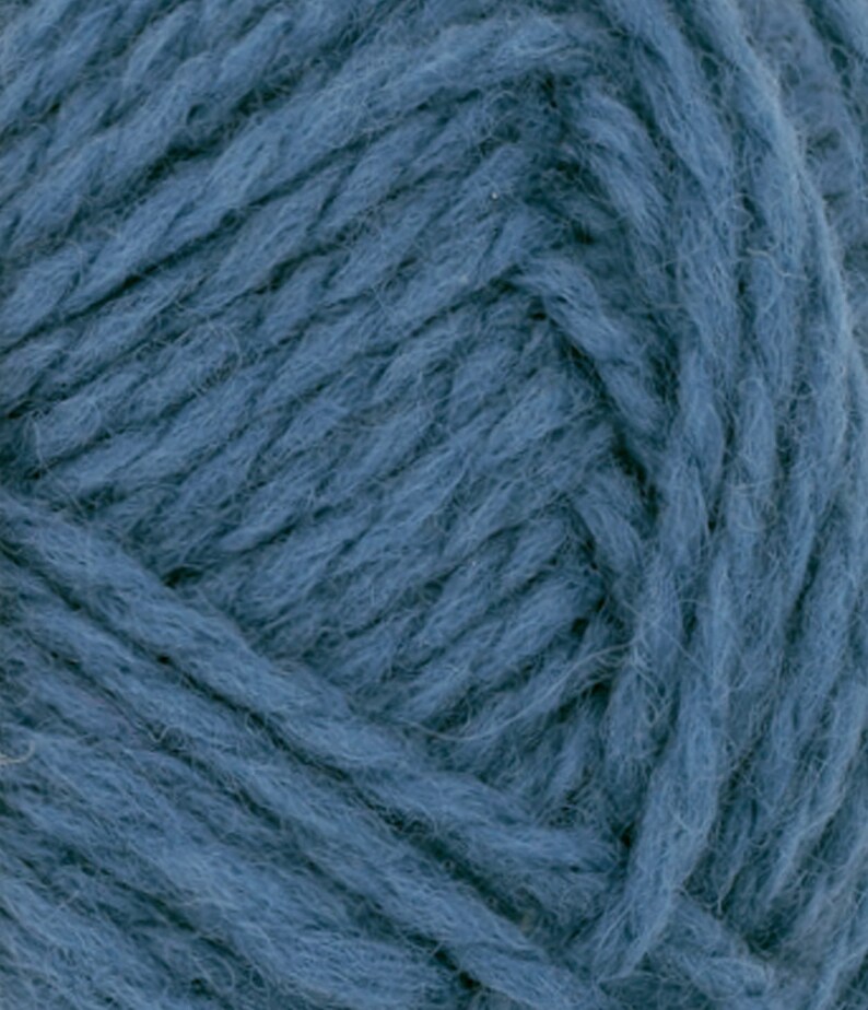 May include: A close-up view of a skein of thick, deep blue yarn. The fibers are twisted into a multi-ply strand with a soft, slightly fuzzy texture. The individual threads are clearly visible, showing a consistent, rich blue color throughout the entire surface of the yarn ball.