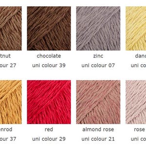May include: A collection of eight yarn samples in various colors, including chestnut, chocolate, zinc, dandelion, goldenrod, red, almond rose, and rose water. Each sample is labeled with its color name and a unique identifier.