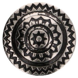 Könnte beinhalten: Ein silberner und schwarzer Metallknopf mit einem runden Design, das konzentrische Kreise und einen Stern in der Mitte zeigt.