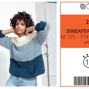 May include: A woman wearing a color-blocked sweater with a cream, light blue, and navy blue design. The sweater has long sleeves and a crew neck. The image also includes a label with the text "SWEATER MARINE".