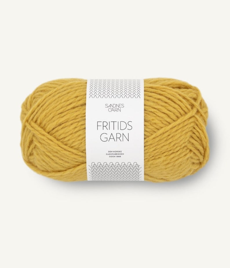 May include: A ball of yellow yarn with a white label that reads 'SADNES GARN FRITIDS GARN DEN NORSKE GARNFABRIKKEN SIDEN 1888'