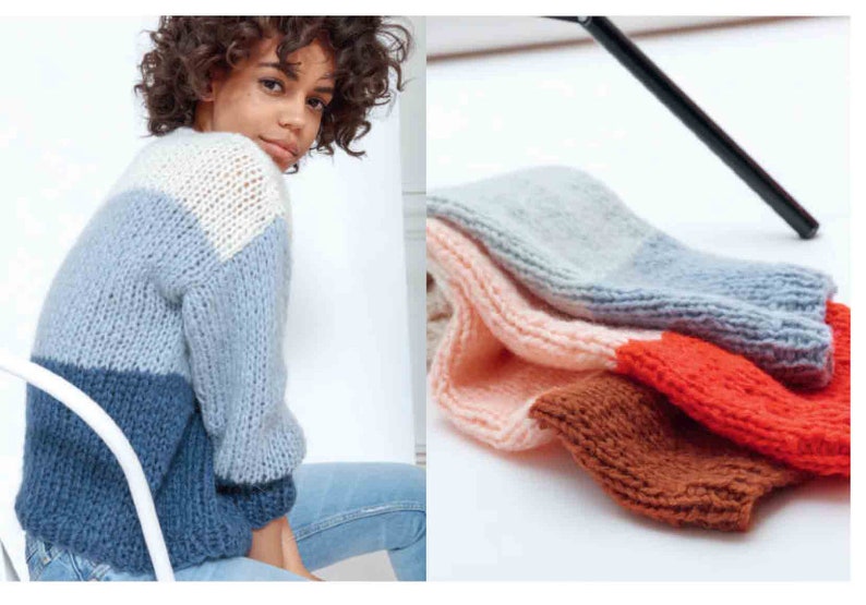 May include: A woman wearing a color-blocked sweater in shades of white, light blue, and navy blue. Beside the woman are several knitted arm warmers in various colors, including pink, gray, brown, and orange. The items appear to be handmade.