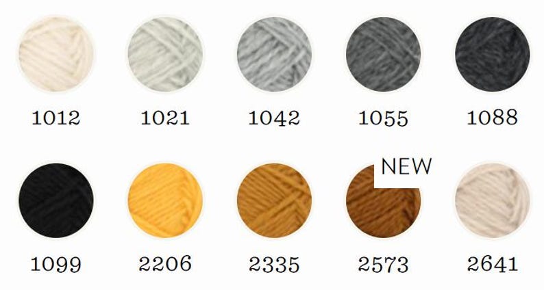 May include: A collection of ten circular yarn samples arranged in two rows, featuring colors ranging from cream, light gray, and charcoal to black, yellow, mustard, and brown. Each sample is labeled with a numerical code, and one is marked NEW.